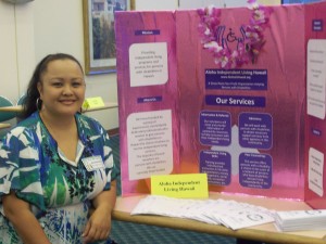 Photo of Executive Director, Roxanne Bolden, sitting in front of an AILH display board.