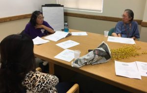 Photo of Val, Lenora, and Yen gathered around a conference table