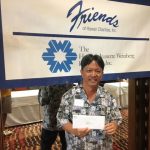 Photo of Thomas Lum with check from Friends of Hawaii Charities