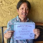 Photo of Thomas Lum holding certificate of appreciation