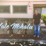Photo of Anthony Byrd standing next to Hale Mohalu sign