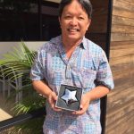 Photo of Thomas Lum holding star shaped award
