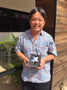 Photo of Thomas Lum holding star shaped award