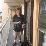 Photo of Jonathan Ching next to his new apartment