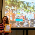 Photo of Kathleen holding packet at Maui Charity Walk Kickoff event