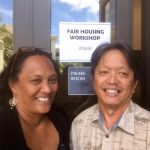 Photo of Julie and Tom in front of sign for Fair Housing Workshop