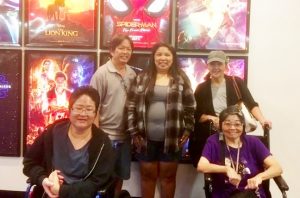 Photo of Hui Malama Po`o members standing in front of movie posters